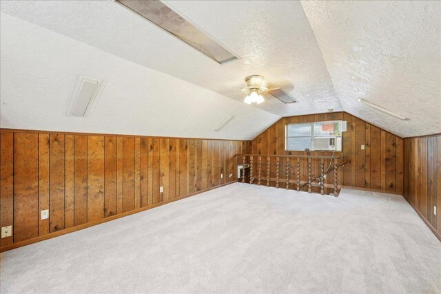 345 Mayhaw Dr, Vidor, TX 77662 - additional living space featuring vaulted ceiling, wooden walls, carpet floors, and a textured ceiling