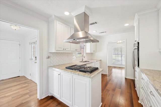 345 Mayhaw Dr, Vidor, TX 77662 - kitchen featuring white cabinetry, a sink, island exhaust hood, and appliances with stainless steel finishes