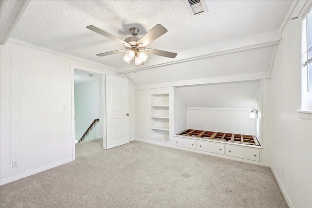 345 Mayhaw Dr, Vidor, TX 77662 - interior space featuring a ceiling fan, vaulted ceiling with beams, a textured ceiling, baseboards, and carpet