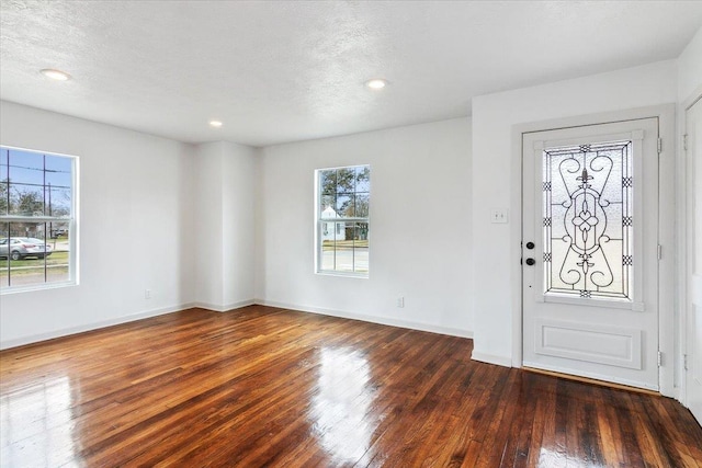 foyer with a textured ceiling and dark hardwood / wood-style floors