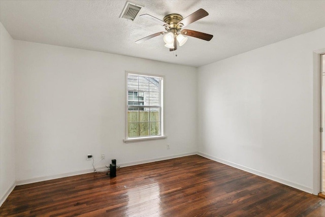 empty room with ceiling fan, dark wood-type flooring, and a textured ceiling