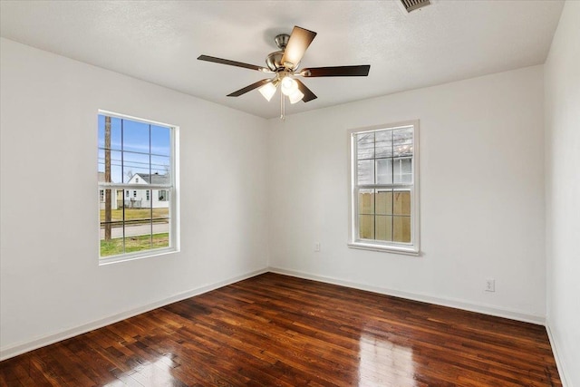 unfurnished room with ceiling fan and dark hardwood / wood-style flooring