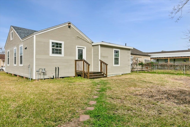 rear view of house featuring a yard