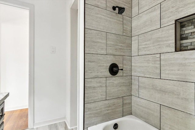 bathroom featuring vanity, hardwood / wood-style floors, and tiled shower / bath