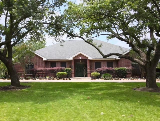 2460 W Norman Cir, Orange, TX 77630 - ranch-style home with a front yard and brick siding