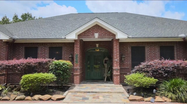 2460 W Norman Cir, Orange, TX 77630 - doorway to property with brick siding and roof with shingles
