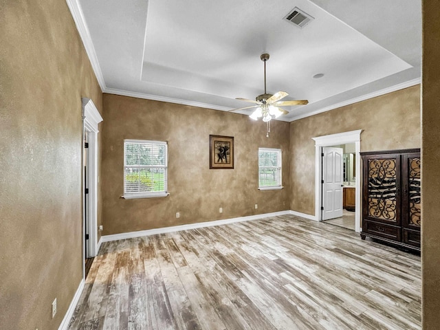 2460 W Norman Cir, Orange, TX 77630 - empty room featuring healthy amount of natural light, wood finished floors, a ceiling fan, a tray ceiling, and ornamental molding