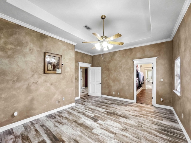 2460 W Norman Cir, Orange, TX 77630 - unfurnished bedroom featuring wood finished floors, a tray ceiling, baseboards, crown molding, and a ceiling fan