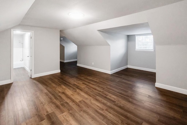 additional living space with dark hardwood / wood-style floors and lofted ceiling