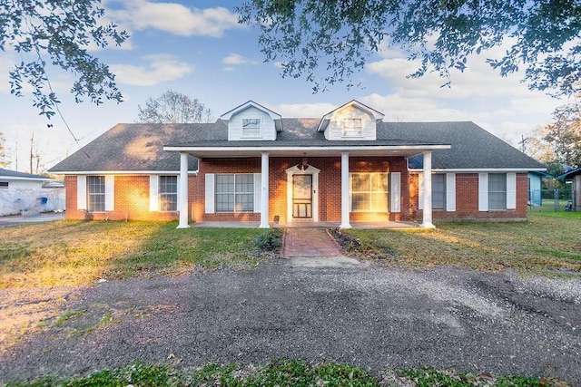 view of front of house featuring covered porch and a front lawn