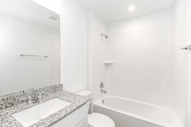 full bathroom with vanity, tiled shower / bath combo, and toilet