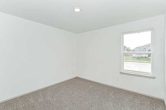 unfurnished room with carpet flooring and a wealth of natural light