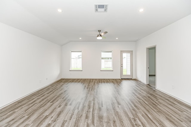 unfurnished living room featuring ceiling fan, vaulted ceiling, and light wood-type flooring