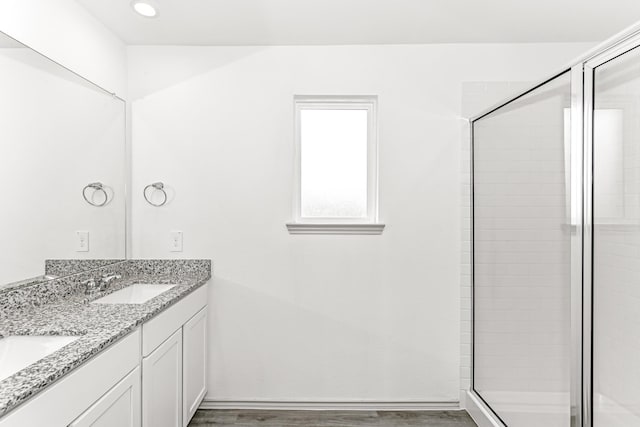 bathroom featuring hardwood / wood-style floors, vanity, and a shower with shower door