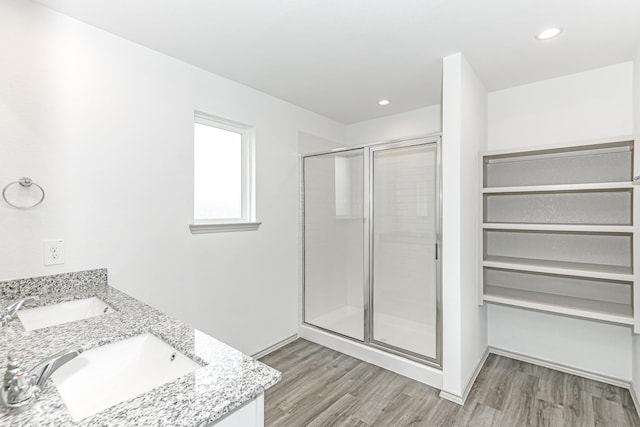 bathroom with hardwood / wood-style flooring, vanity, and a shower with door