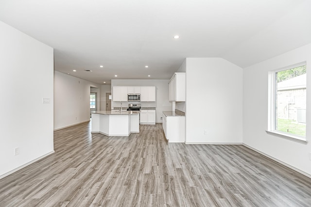 unfurnished living room featuring light hardwood / wood-style flooring and lofted ceiling