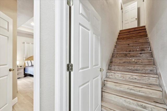 stairs with a textured wall and wood finished floors