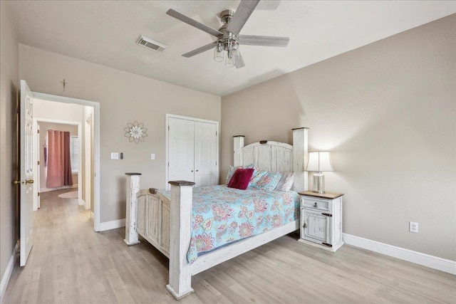 bedroom with baseboards, a closet, visible vents, and light wood-style floors