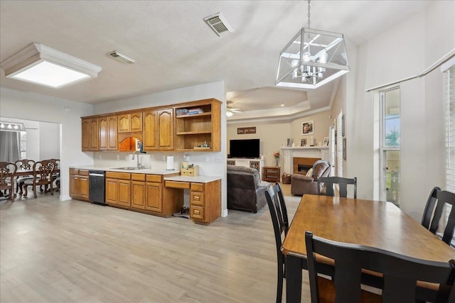 kitchen with light countertops, brown cabinets, visible vents, and light wood finished floors