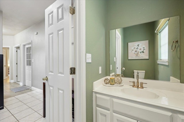 bathroom with baseboards, vanity, toilet, and tile patterned floors