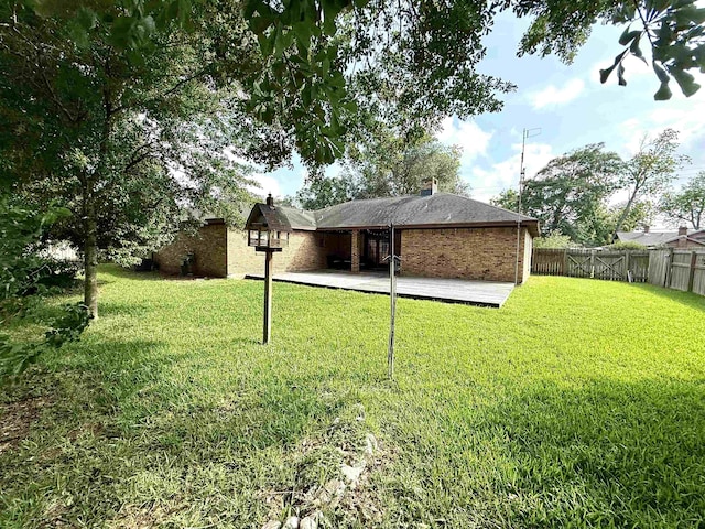back of property featuring a yard, brick siding, a chimney, and a fenced backyard