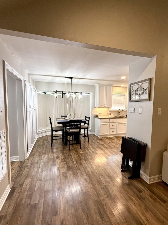 dining room featuring baseboards and dark wood-style flooring