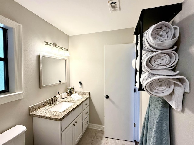 bathroom featuring tile patterned flooring, visible vents, vanity, toilet, and baseboards