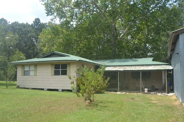 rear view of house featuring a lawn