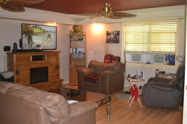 living room with ceiling fan, light hardwood / wood-style floors, crown molding, and cooling unit