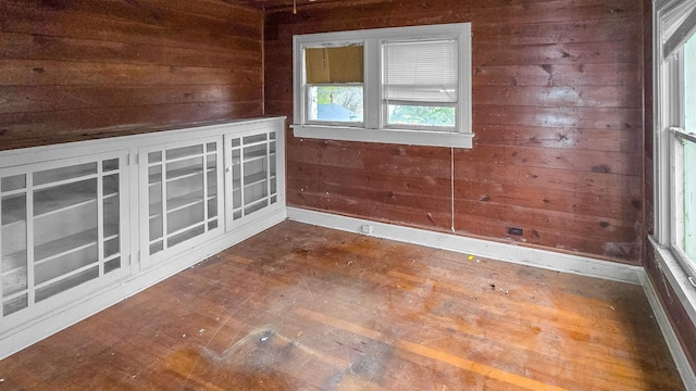 spare room featuring hardwood / wood-style flooring and wooden walls