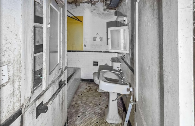 bathroom featuring tile walls, tile patterned floors, and toilet