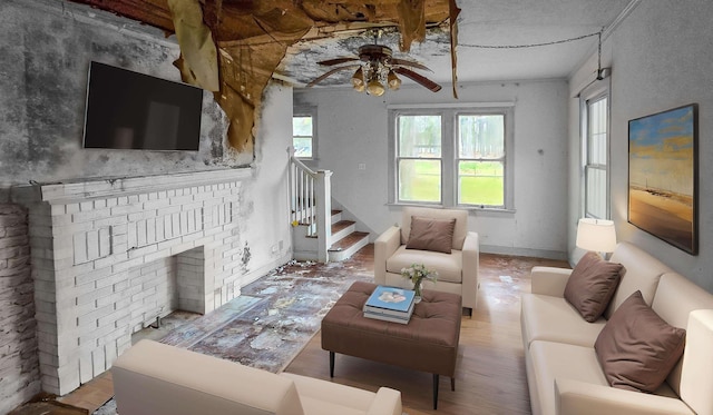 living room featuring a fireplace, light hardwood / wood-style floors, and ceiling fan