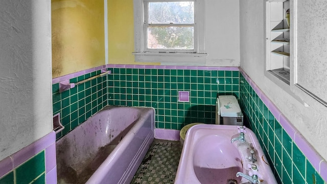 bathroom featuring sink, tile walls, and a washtub