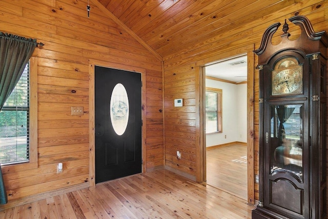 foyer featuring light hardwood / wood-style floors, vaulted ceiling, wooden walls, and wood ceiling