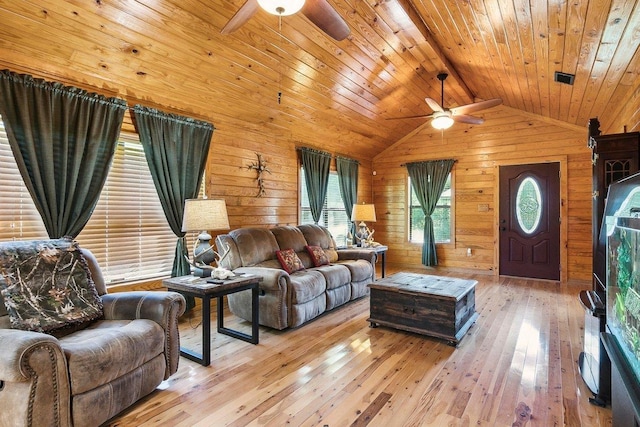 living room with vaulted ceiling with beams, wood walls, light wood-type flooring, and wooden ceiling