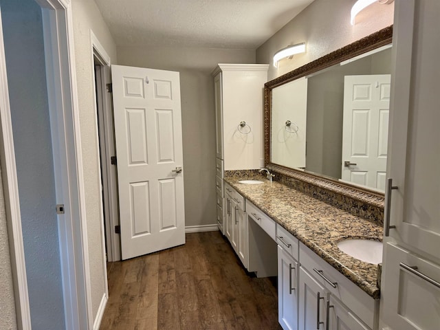 5835 Calder Ave, Beaumont, TX 77706 - bathroom featuring wood finished floors, double vanity, a textured ceiling, and baseboards
