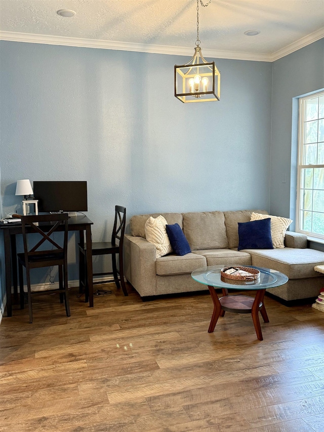 living area with an inviting chandelier, wood finished floors, and crown molding