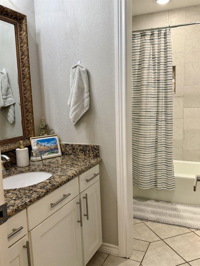 bathroom featuring tile patterned flooring, vanity, shower / tub combo, and a textured wall