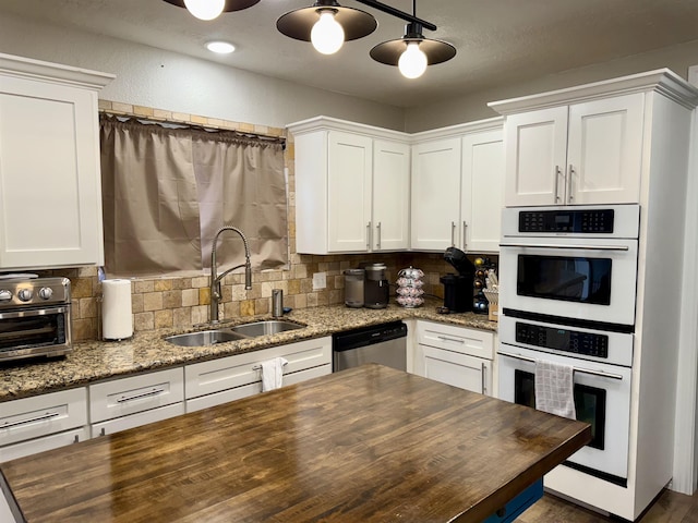 kitchen featuring dishwasher, double oven, butcher block counters, and a sink