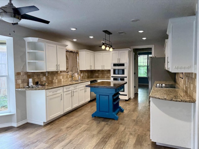 5835 Calder Ave, Beaumont, TX 77706 - kitchen featuring open shelves, a sink, white cabinetry, ceiling fan, and tasteful backsplash