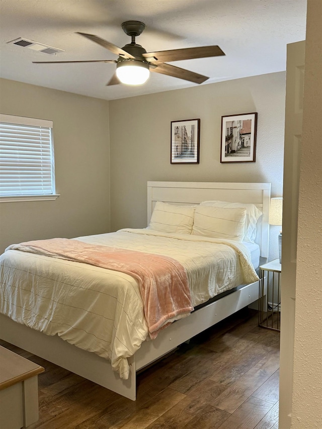 bedroom with visible vents, a ceiling fan, and wood finished floors