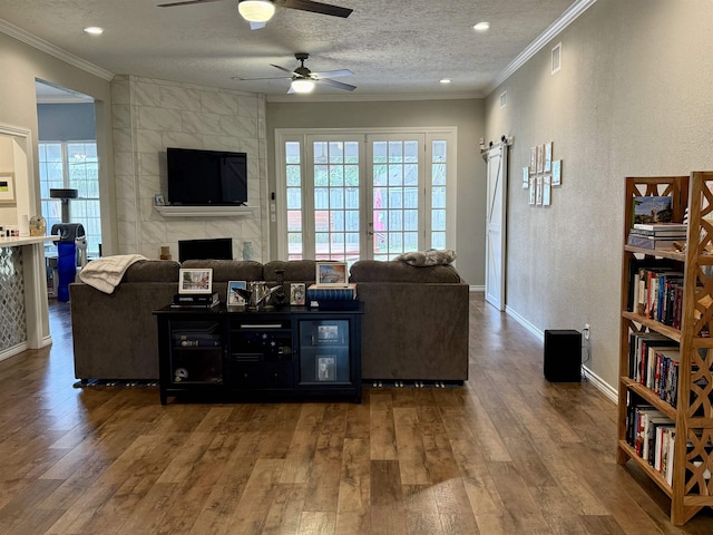 living area featuring visible vents, a textured ceiling, crown molding, and wood finished floors