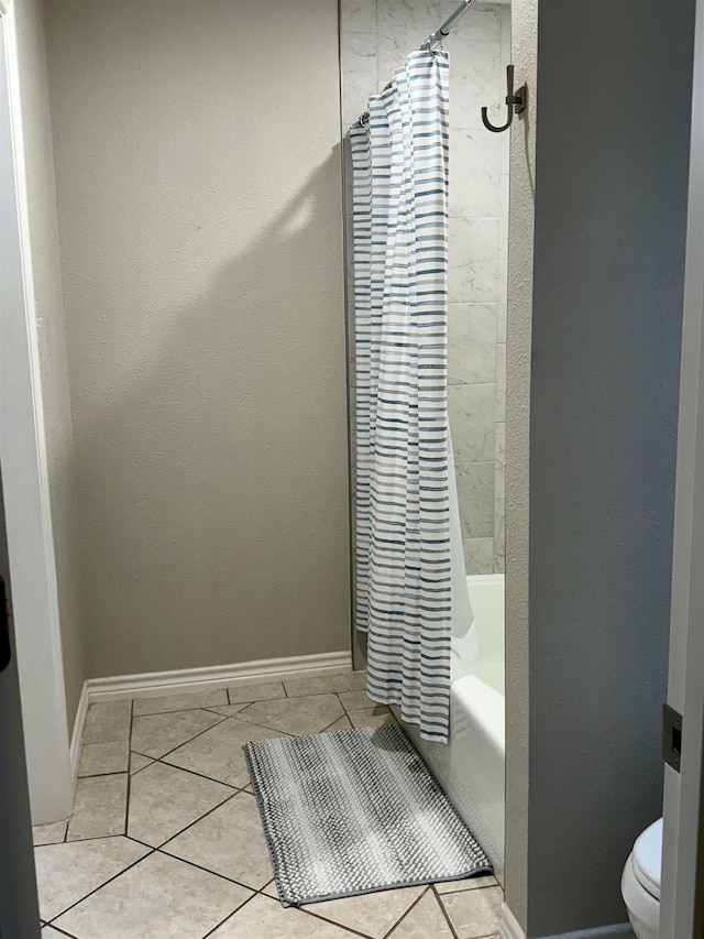 full bathroom featuring tile patterned floors, toilet, shower / tub combo, and baseboards