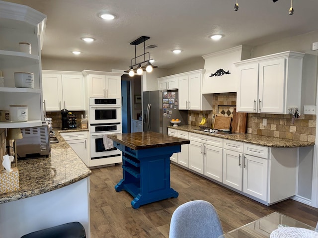 kitchen with double oven, butcher block counters, stainless steel refrigerator with ice dispenser, white cabinets, and open shelves