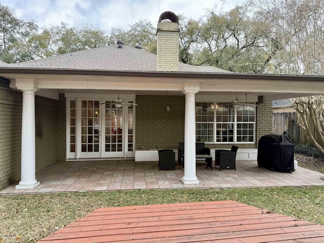 rear view of property featuring fence, a ceiling fan, and brick siding