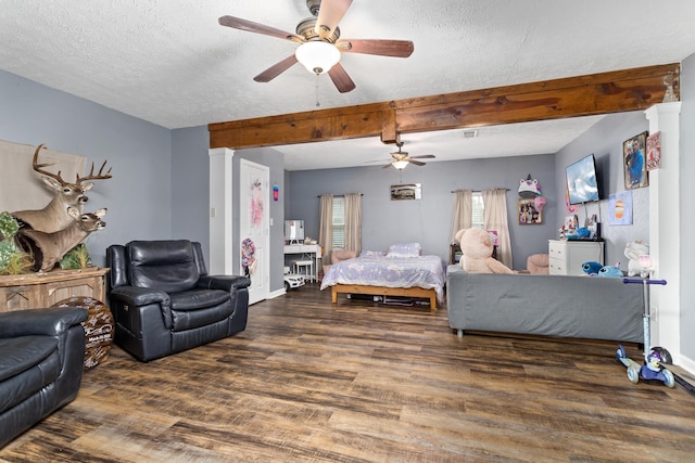 bedroom with wood finished floors, baseboards, ceiling fan, a textured ceiling, and beamed ceiling