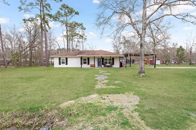 view of front facade featuring an outbuilding, stucco siding, and a front lawn