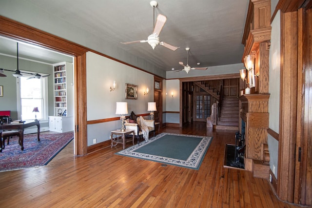 living room with built in shelves and wood-type flooring