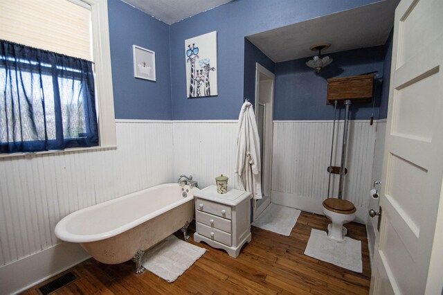 2108 Harrison Ave, Beaumont, TX 77701 - bathroom featuring wainscoting, a soaking tub, and wood finished floors