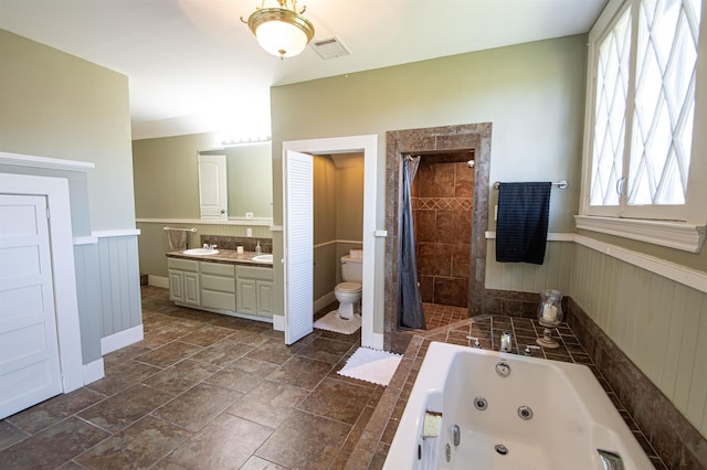 full bathroom with toilet, vanity, and separate shower and tub